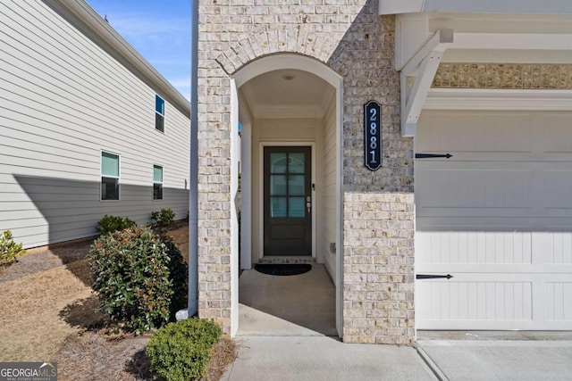 property entrance featuring a garage and stone siding