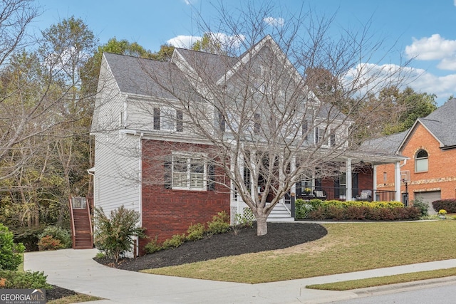 view of front of property with brick siding, a porch, and a front yard