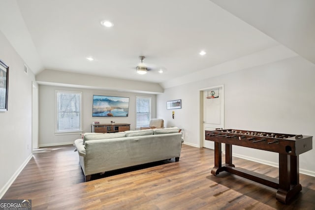 living room with vaulted ceiling, dark wood-type flooring, and baseboards