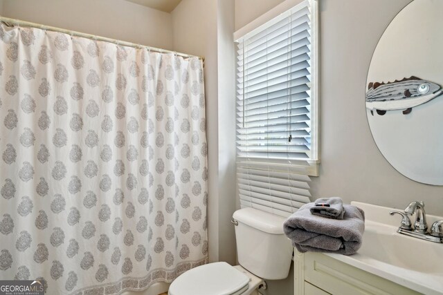 bathroom featuring toilet, curtained shower, and vanity