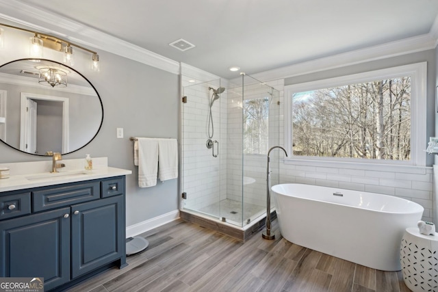 full bathroom featuring ornamental molding, a freestanding tub, visible vents, and a shower stall