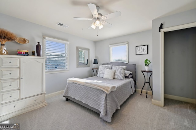 bedroom featuring baseboards, ceiling fan, visible vents, and light colored carpet