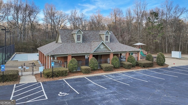 uncovered parking lot featuring a fenced front yard and a gate