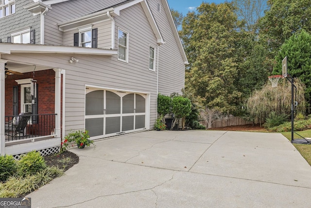 view of side of home featuring concrete driveway and an attached garage