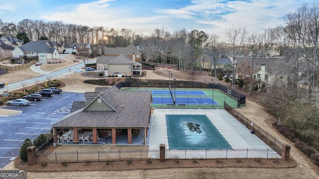 view of pool featuring fence private yard, a tennis court, and a residential view