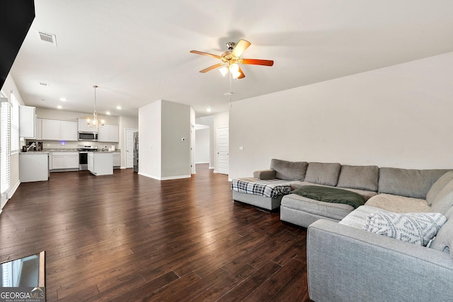 living area featuring recessed lighting, visible vents, dark wood-type flooring, baseboards, and ceiling fan with notable chandelier