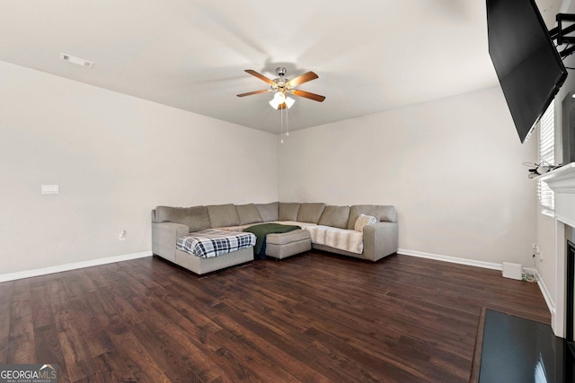 unfurnished living room featuring dark wood-style flooring, a fireplace, baseboards, and ceiling fan