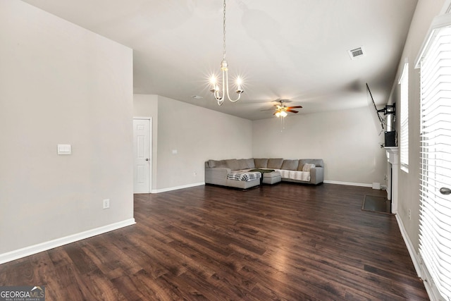 unfurnished living room featuring dark wood-style floors, ceiling fan with notable chandelier, visible vents, and baseboards