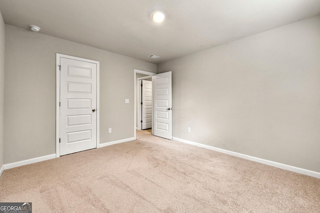 unfurnished bedroom with baseboards and light colored carpet