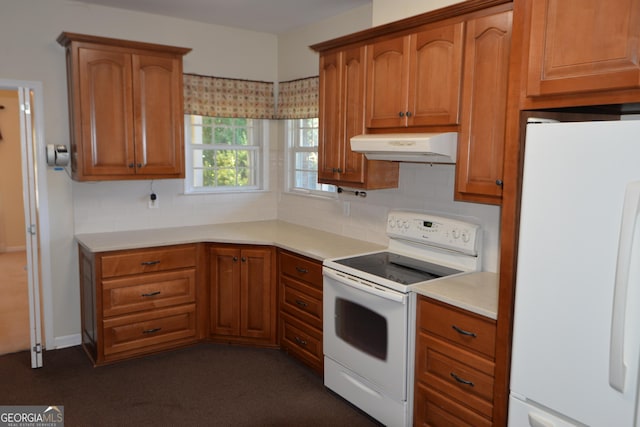 kitchen with light countertops, white appliances, brown cabinetry, and under cabinet range hood