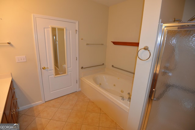 bathroom with a stall shower, vanity, tile patterned flooring, a jetted tub, and baseboards