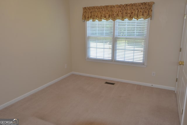 spare room with baseboards, visible vents, and carpet flooring