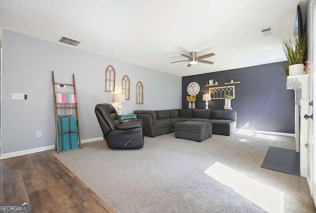 carpeted living room featuring visible vents, ceiling fan, and baseboards