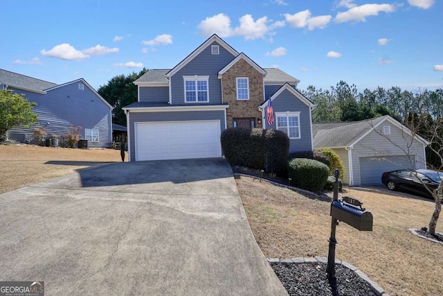 traditional-style house featuring a garage, brick siding, and driveway