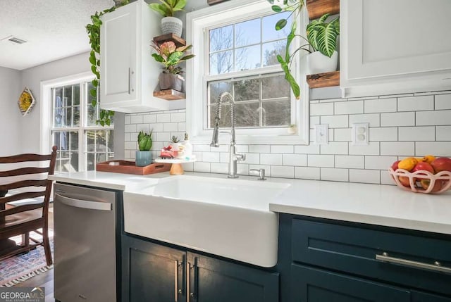 kitchen featuring a sink, visible vents, white cabinets, light countertops, and dishwasher