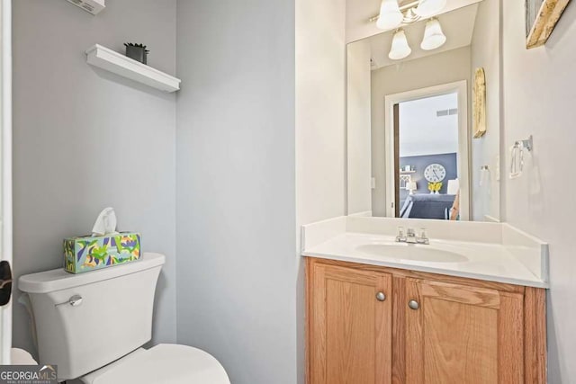 bathroom featuring toilet, visible vents, and vanity