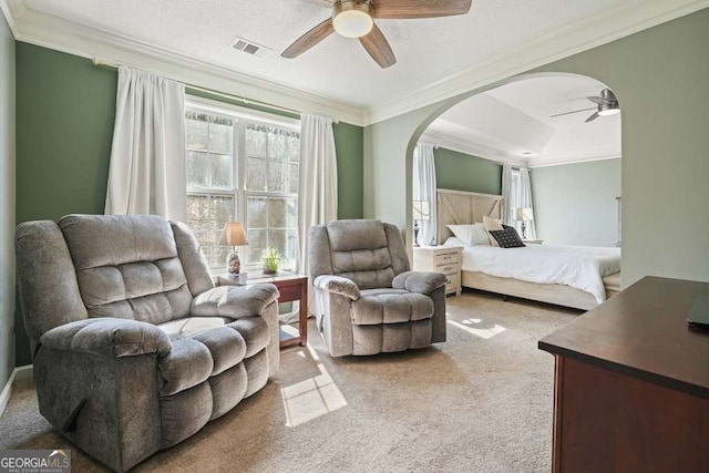 bedroom with visible vents, arched walkways, ceiling fan, crown molding, and carpet flooring