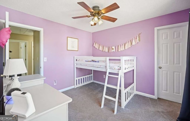 carpeted bedroom with ceiling fan and baseboards