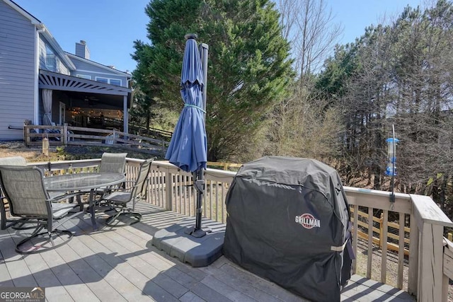 deck featuring outdoor dining space and area for grilling