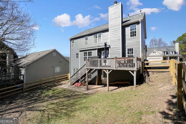 back of property featuring a yard, a fenced backyard, a chimney, and a wooden deck