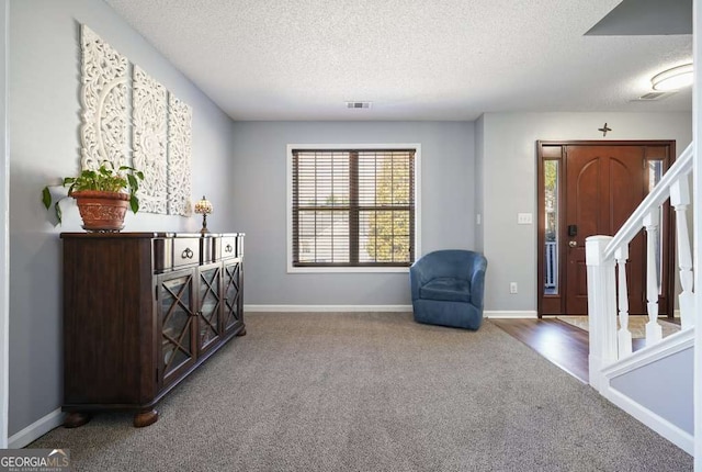 living area featuring stairs, carpet floors, visible vents, and baseboards