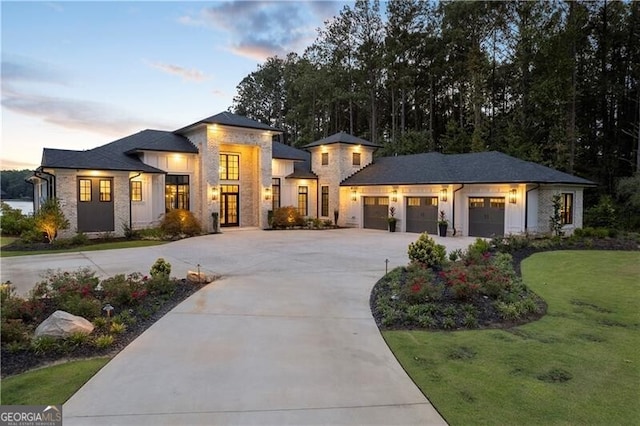 prairie-style home with a front lawn, driveway, and an attached garage