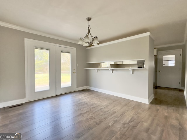 interior space with light wood finished floors, visible vents, and crown molding