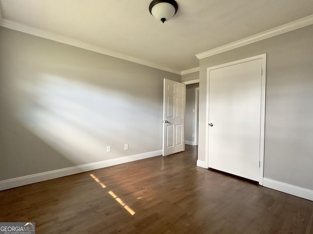 unfurnished bedroom featuring dark wood-style floors, ornamental molding, and baseboards