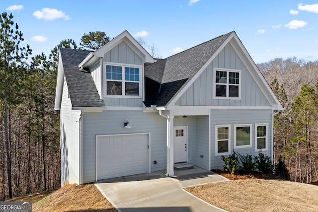 view of front of home with board and batten siding, concrete driveway, roof with shingles, and a garage