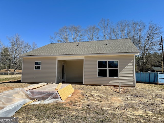 back of house with a shingled roof