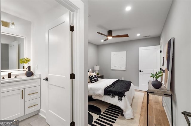 bedroom with light wood-style floors, a sink, and recessed lighting