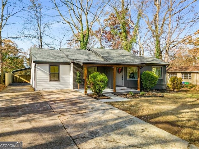 view of front of property with a porch, concrete driveway, and a front yard