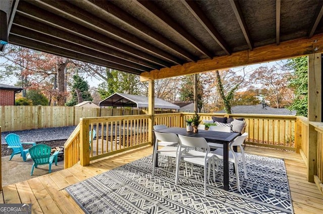 wooden deck with outdoor dining space and fence