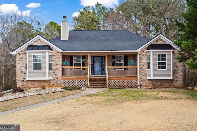 single story home featuring covered porch, roof with shingles, brick siding, and a chimney