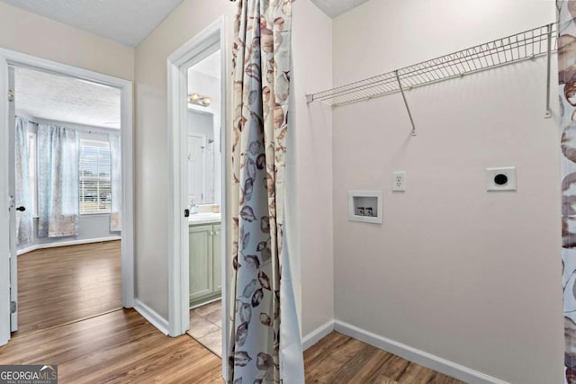 clothes washing area with laundry area, wood finished floors, hookup for a washing machine, and electric dryer hookup