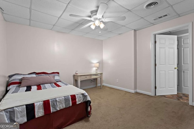 bedroom with a paneled ceiling, carpet, visible vents, and a ceiling fan