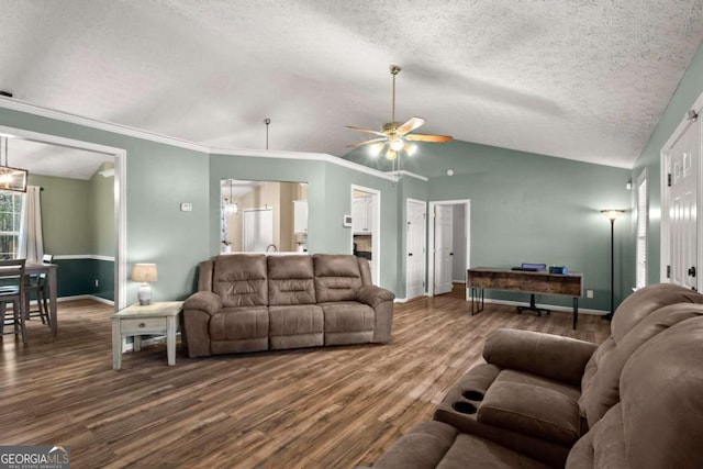 living area featuring lofted ceiling, ornamental molding, a textured ceiling, wood finished floors, and baseboards