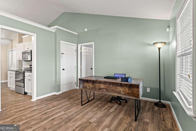 office area featuring light wood finished floors, baseboards, and vaulted ceiling