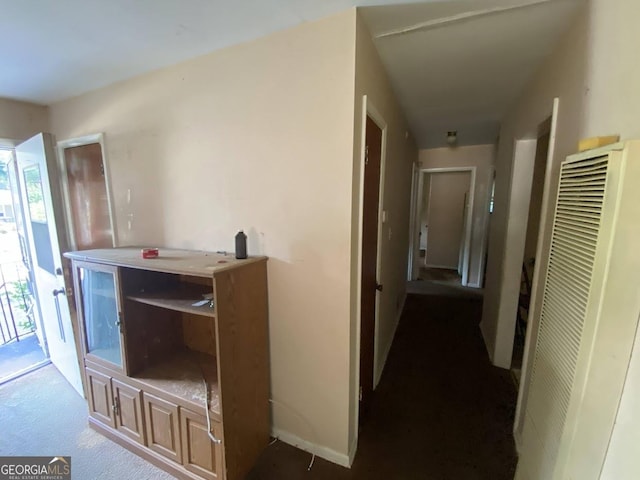 hallway with a heating unit and baseboards