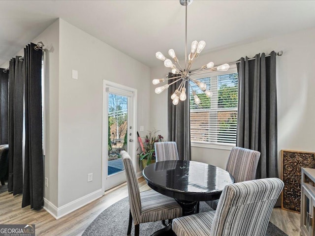 dining room featuring a chandelier, light wood-style flooring, and baseboards