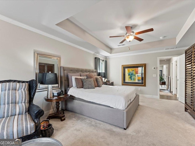 carpeted bedroom featuring visible vents, a tray ceiling, and baseboards