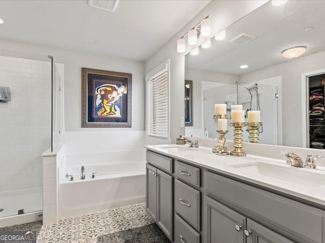 bathroom with a stall shower, a garden tub, and a sink