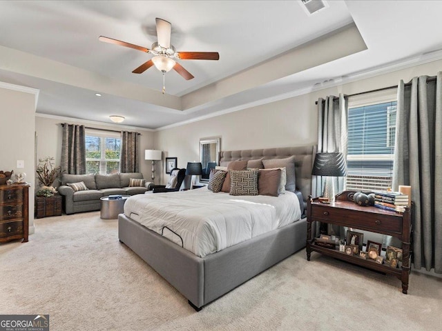 bedroom with ornamental molding, a tray ceiling, carpet flooring, and ceiling fan