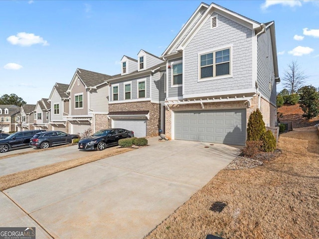 townhome / multi-family property featuring a residential view, concrete driveway, brick siding, and an attached garage