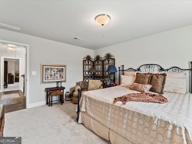 bedroom with baseboards, attic access, visible vents, and carpet flooring