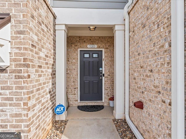 entrance to property featuring brick siding