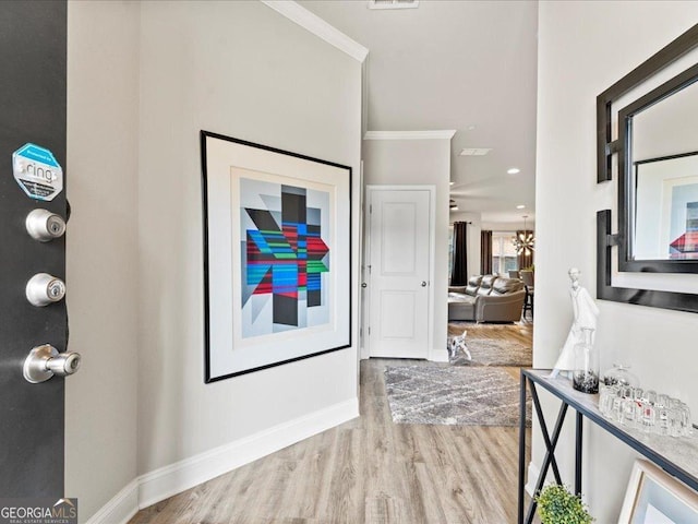 foyer with a chandelier, ornamental molding, wood finished floors, and baseboards