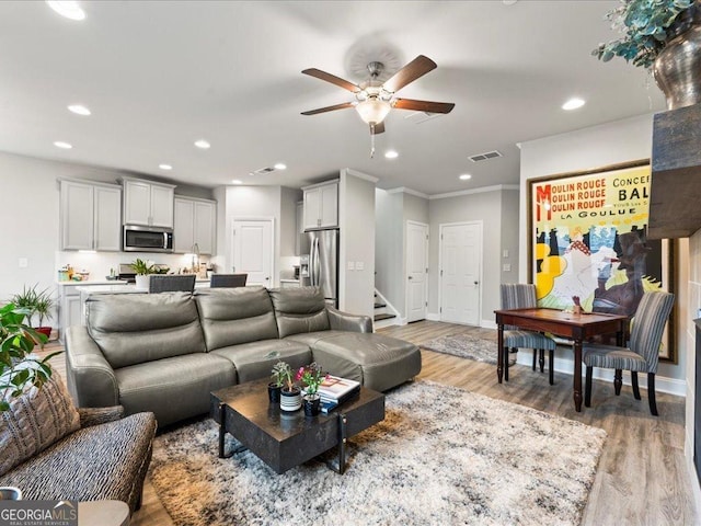 living area with baseboards, light wood finished floors, visible vents, and recessed lighting