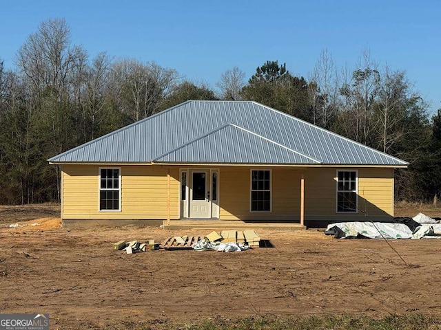 back of house featuring metal roof