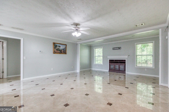 unfurnished living room with ornamental molding, a glass covered fireplace, visible vents, and baseboards